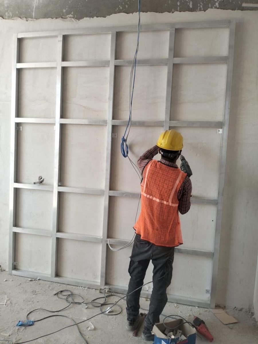 Isquare site team fixing a metal frame for a wall panel